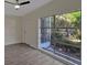 Bright bedroom with gray laminated flooring featuring a ceiling fan and a large window at 819 Edgewater Dr, Eustis, FL 32726