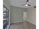 Neutral bedroom featuring new light grey paint, laminated flooring, ceiling fan and a large window at 819 Edgewater Dr, Eustis, FL 32726