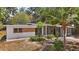 Side view of a single-story home featuring a screened porch and mature landscaping at 819 Edgewater Dr, Eustis, FL 32726