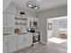 Modern kitchen featuring stainless steel appliances, white cabinetry, and floating shelves at 819 Edgewater Dr, Eustis, FL 32726