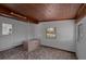 Living room featuring a wood ceiling, tile floor, and a door leading to the kitchen at 819 Edgewater Dr, Eustis, FL 32726