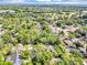 Aerial view of a tranquil neighborhood with tree-lined streets, featuring homes with manicured lawns and mature trees at 1039 Whispering Cv, Casselberry, FL 32707