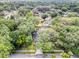 A high angle aerial view showing mature tree growth, a screened-in pool and the surrounding neighborhood at 1039 Whispering Cv, Casselberry, FL 32707