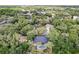Aerial view of a home with a dark roof and screened in swimming pool, nestled within a lush green neighborhood at 1039 Whispering Cv, Casselberry, FL 32707