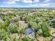An aerial view of a neighborhood with tree lined streets and a home featuring a screened pool in the backyard at 1039 Whispering Cv, Casselberry, FL 32707