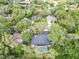 Birds eye view of neighborhood homes surrounded by mature trees with a focus on one with a screened in pool at 1039 Whispering Cv, Casselberry, FL 32707