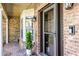 Covered front porch with brick flooring, columns, and decorative potted plants at 1039 Whispering Cv, Casselberry, FL 32707