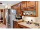 Kitchen area with stainless steel refrigerator, granite counters and custom wood cabinets at 1039 Whispering Cv, Casselberry, FL 32707