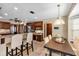 Open kitchen with breakfast bar flows seamlessly into the breakfast nook. Stainless fridge and dark-wood cabinets at 1039 Whispering Cv, Casselberry, FL 32707
