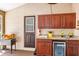 This patio wet bar offers dark wood cabinets, granite countertop, mini fridge, and direct patio access at 1039 Whispering Cv, Casselberry, FL 32707