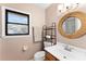 Bathroom featuring neutral colors, a decorative mirror, and a window with a beautiful stain glass design at 1107 Monroe Ave, St Cloud, FL 34769