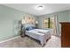 Bedroom featuring light green walls, natural light, and calming decor, creating a serene space at 1107 Monroe Ave, St Cloud, FL 34769