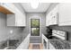 Efficient kitchen with white cabinets, granite countertops, and stainless-steel appliances at 1107 Monroe Ave, St Cloud, FL 34769