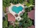 Aerial view of a clover-shaped pool surrounded by lounge chairs and lush greenery near the building at 1111 Salerno Ct # Ge, Orlando, FL 32806