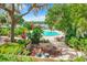 Resort-style pool area with dining tables, lush tropical landscaping, and lake views at 1111 Salerno Ct # Ge, Orlando, FL 32806
