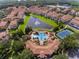 Beautiful aerial view of a community with a pool, tennis court, clubhouse, and scenic water features at 1120 Parma Cir, Lake Mary, FL 32746