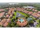 This gorgeous aerial view shows a community with a pool, tennis court, clubhouse, and lake at 1120 Parma Cir, Lake Mary, FL 32746