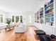Living room featuring hardwood floors, a built-in bookcase filled with books and decor, and large windows at 1120 Parma Cir, Lake Mary, FL 32746