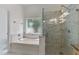 Bathroom with a separate tub and shower, featuring marble tile and a window providing natural light at 11705 Binfield Ct, Orlando, FL 32837