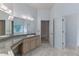 Bathroom featuring a double vanity with granite countertops, marble floors, and ample lighting at 11705 Binfield Ct, Orlando, FL 32837