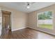 Neutral bedroom features hardwood floors, a ceiling fan, and a window with a pleasant view at 11705 Binfield Ct, Orlando, FL 32837