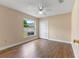Bedroom featuring a ceiling fan, wood floors, and a large window at 11705 Binfield Ct, Orlando, FL 32837