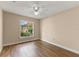 Neutral bedroom features hardwood floors, a ceiling fan, and a window with a pleasant view at 11705 Binfield Ct, Orlando, FL 32837