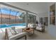 Screened-in patio with comfortable seating overlooking the sparkling swimming pool at 11705 Binfield Ct, Orlando, FL 32837