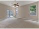 Spacious main bedroom with carpet flooring, ceiling fan, and sliding door access to the screened-in pool area at 11705 Binfield Ct, Orlando, FL 32837