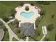 Aerial view of a heart shaped community pool with lounge chairs, a spa, and lush landscaping at 12079 Scrub Palm Ln, Orlando, FL 32824