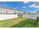 Spacious backyard features well-manicured lawn, complemented by a pristine white fence and shade trees for privacy at 12079 Scrub Palm Ln, Orlando, FL 32824