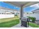 View of the backyard including the stainless steel grill, green grass and surrounding white fence at 12079 Scrub Palm Ln, Orlando, FL 32824