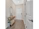 Inviting entryway with wood-look floors, stylish console table, a round mirror, and white doors at 12079 Scrub Palm Ln, Orlando, FL 32824