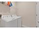 Functional laundry room equipped with a washer, dryer, and shelving for storing supplies at 12079 Scrub Palm Ln, Orlando, FL 32824