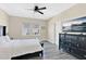 Bright main bedroom featuring wood floors, a ceiling fan, and a large window for natural light at 12079 Scrub Palm Ln, Orlando, FL 32824
