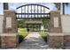 Inviting Cypress Park entrance featuring stone pillars, decorative signage, and a scenic pathway to a gazebo at 12079 Scrub Palm Ln, Orlando, FL 32824