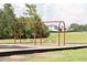 Playground swings surrounded by lush green space in a vibrant community park at 12079 Scrub Palm Ln, Orlando, FL 32824
