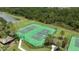 Aerial view of the community tennis courts surrounded by lush landscaping and adjacent to a pond at 12079 Scrub Palm Ln, Orlando, FL 32824