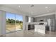 Modern kitchen with stainless steel appliances, gray cabinets, and large sliding glass doors to the backyard at 1341 Wycliffe Way, St Cloud, FL 34771