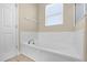 A bright bathroom with a white soaking tub, window for natural light and neutral walls at 14517 Black Lake Preserve St, Winter Garden, FL 34787