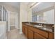 Bright bathroom with a dual sink vanity, granite countertop, and walk-in closet access at 14517 Black Lake Preserve St, Winter Garden, FL 34787