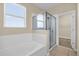 Bright bathroom featuring a soaking tub and glass-enclosed shower with a tiled floor at 14517 Black Lake Preserve St, Winter Garden, FL 34787