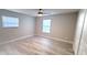 Spacious bedroom featuring wood-look floors, a ceiling fan, and ample natural light from two windows at 1472 6Th Ave, Deland, FL 32724