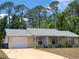 Charming single-story home with a well-maintained lawn and attached garage at 1472 6Th Ave, Deland, FL 32724