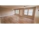 Spacious living room features wood-look floors, a ceiling fan, and plentiful natural light from the windows at 1472 6Th Ave, Deland, FL 32724