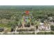 Expansive aerial view of the property, featuring a pond and surrounding lush greenery at 1526 Maytown Rd, Oak Hill, FL 32759