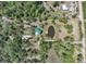 Captivating aerial perspective showcasing the home with a pond amid a densely wooded landscape at 1526 Maytown Rd, Oak Hill, FL 32759