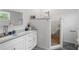 Modern bathroom with marble countertops, dual sinks, and a walk-in shower with unique pebble floor at 1526 Maytown Rd, Oak Hill, FL 32759
