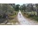 Picturesque long driveway leading to property with mature trees and wooden fencing at 1526 Maytown Rd, Oak Hill, FL 32759