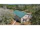 Features a large building with a green roof and a balcony, nestled among trees at 1526 Maytown Rd, Oak Hill, FL 32759